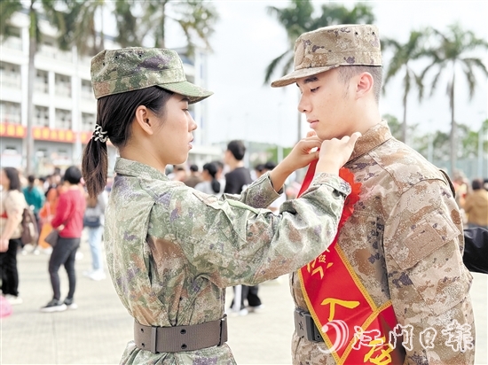 在歡送儀式現(xiàn)場(chǎng)，老兵姐姐為新兵弟弟整理軍裝。