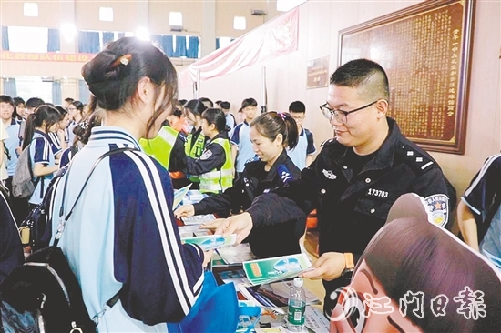 民警向?qū)W生發(fā)放安全知識宣傳資料。