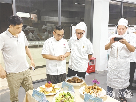 伍立更（左二）對學(xué)員們的自創(chuàng)菜式一一進(jìn)行點(diǎn)評和指導(dǎo)。