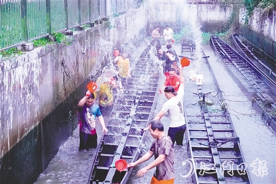 在水口鎮(zhèn)龍東村委會欖沖村，村民們合力將深埋河底的龍舟“喚醒”，為即將到來的端午龍舟賽事做準備。