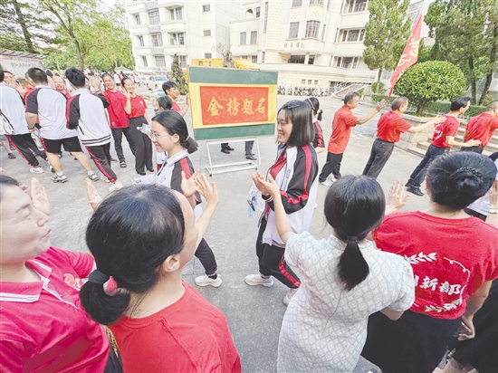 臺(tái)山一中在送考路上設(shè)置了“金榜題名”大字帖，教師身穿紅衣與學(xué)生擊掌，為學(xué)生加油。