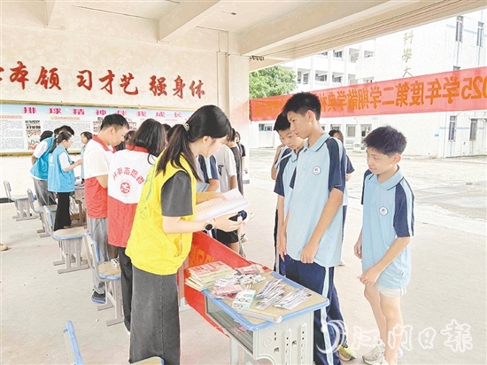 工作人員向?qū)W生宣傳防溺水知識(shí)。