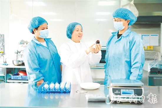 在培訓(xùn)室里，梁艷芬（中間白衣）和大家交流蛋品檢測(cè)方式。