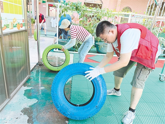 蓬江區(qū)委組織部干部深入幼兒園清理輪胎內(nèi)積水，做好基孔肯雅熱疫情防控工作。