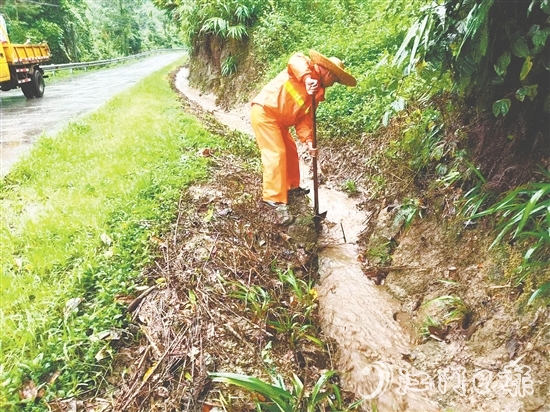 道路養(yǎng)護人員清理被泥沙落葉堵塞的邊溝涵洞，確保雨水快速排走。