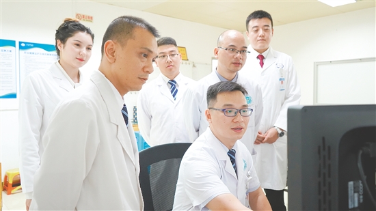 謝志駿（左四）和同事討論影像報告。