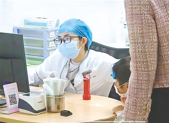 醫(yī)生向患兒及家長了解情況。