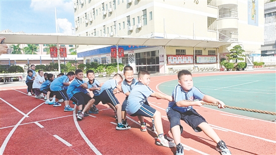 參賽隊員們緊握長繩，齊心協(xié)力，鼓足勁拼命往后拉。