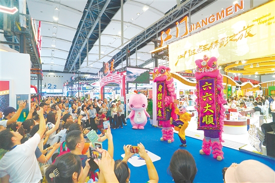 江門展館內(nèi)，醒獅騰躍的精彩表演引得參觀者紛紛舉起手機(jī)，定格這熱鬧瞬間。