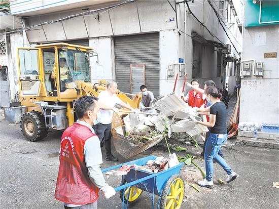 在蓬江區(qū)環(huán)市街道里村社區(qū)舊村片區(qū)，人和機(jī)器齊上陣，清理衛(wèi)生死角。