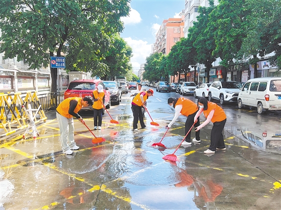 廣東江門中醫(yī)藥職業(yè)學(xué)院大學(xué)生志愿者合力清掃街道積水。
