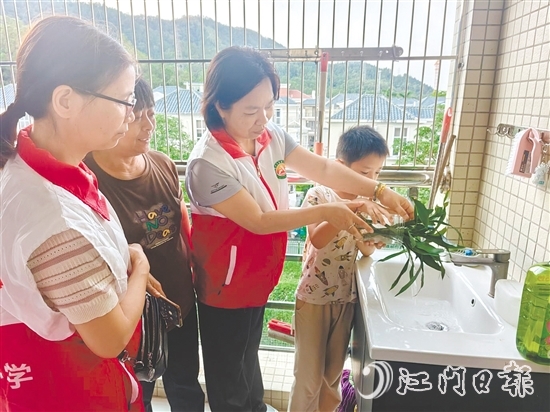 恩平市鰲峰小學(xué)黨員教師入戶指導(dǎo)學(xué)生清積水。